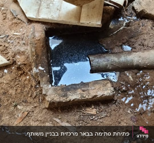 פתח ביוב עם צינור מתכת ונוזל כהה